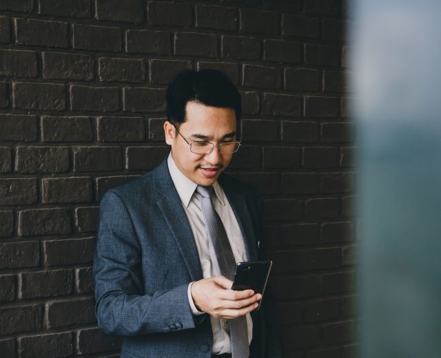 happy-asian-businessman-using-smart-phone-2021-09-04-09-57-06-utc.jpg